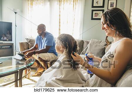 Mother styling hair for daughter in living room View Large Photo Image Stock Photography - Mother styling hair for daughter in living room. Fotosearch