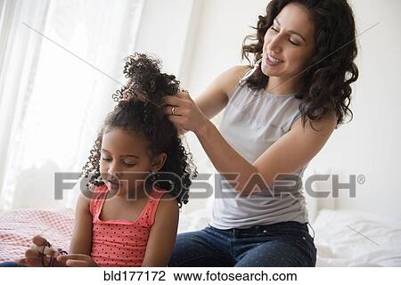 Mother styling hair of daughter View Large Photo Image Stock Image - Mother styling hair of daughter. Fotosearch