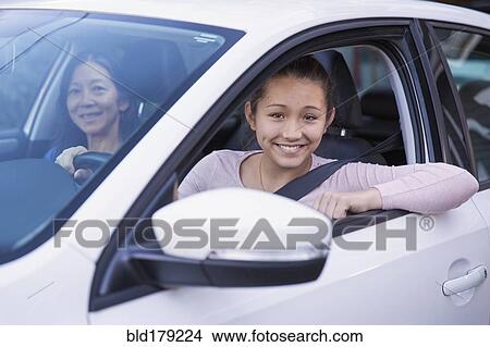 Picture - Mother teaching daughter to drive car. Fotosearch