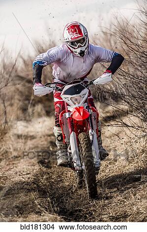 Motorcyclist riding dirt bike on rural path View Large Photo Image Picture - Motorcyclist riding dirt bike on rural path. Fotosearch