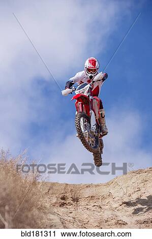 Motorcyclist riding dirt bike on hillside View Large Photo Image Stock Image - Motorcyclist riding dirt bike on hillside. Fotosearch