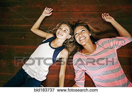 Stock Photo - Native American mother and daughter laying on floor. Fotosearch