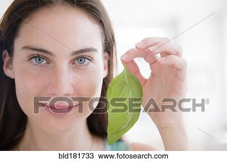 Stock Image - Native American woman holding leaf. Fotosearch