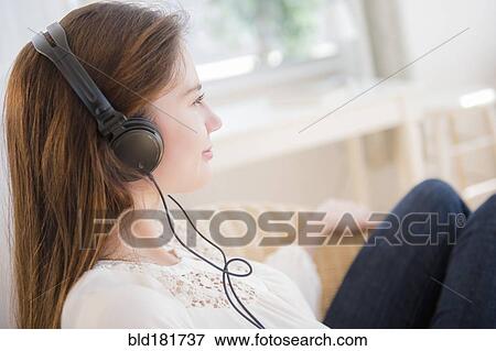 Stock Photo - Native American woman listening to headphones. Fotosearch