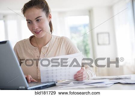 Stock Photo - Native American woman paying bills on computer. Fotosearch