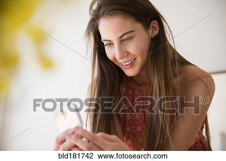Stock Image - Native American woman using cell phone. Fotosearch