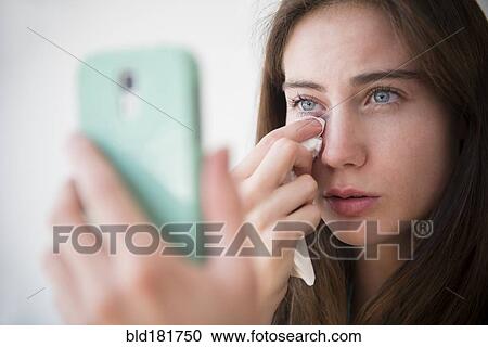 Native American woman with cell phone wiping away tears View Large Photo Image Stock Image - Native American woman with cell phone wiping away tears. Fotosearch