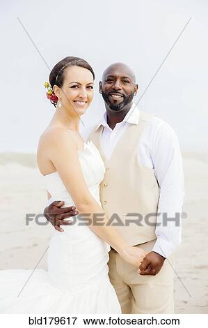 Newlywed couple hugging on beach View Large Photo Image Stock Photo - Newlywed couple hugging on beach. Fotosearch