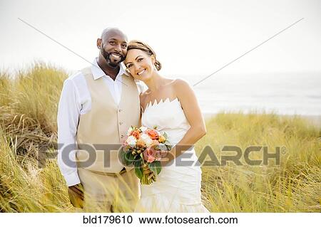 Newlywed couple smiling in grass View Large Photo Image Stock Image - Newlywed couple smiling in grass. Fotosearch