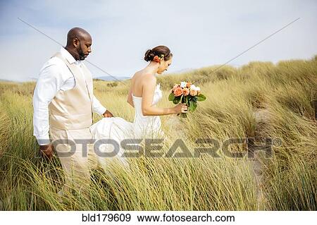 Stock Photo - Newlywed couple walking on beach. Fotosearch