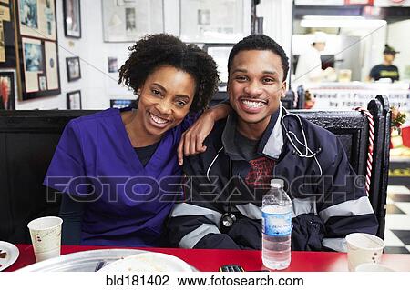 Nurse and paramedic smiling in restaurant View Large Photo Image Stock Image - Nurse and paramedic smiling in restaurant. Fotosearch