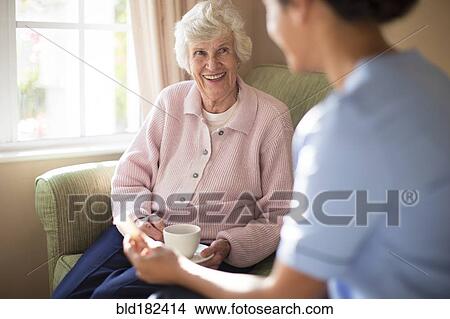 Nurse and patient drinking tea on sofa View Large Photo Image Picture - Nurse and patient drinking tea on sofa. Fotosearch
