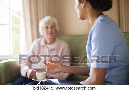 Nurse and patient drinking tea on sofa View Large Photo Image Stock Photography - Nurse and patient drinking tea on sofa. Fotosearch