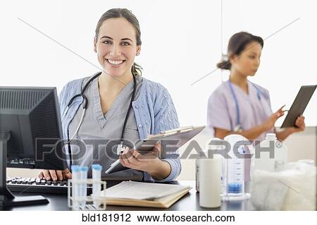 Stock Image - Nurse holding medical chart in hospital. Fotosearch
