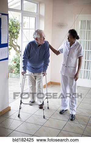 Nurse talking to patient using walker View Large Photo Image Stock Photography - Nurse talking to patient using walker. Fotosearch