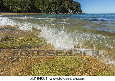 Stock Image - Ocean waves crashing on remote beach. Fotosearch