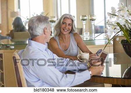 Stock Photo - Older Caucasian couple talking at table. Fotosearch
