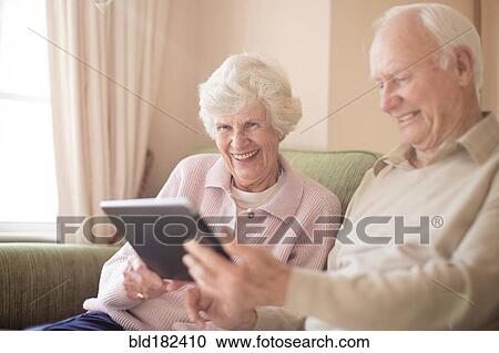 Stock Image - Older Caucasian couple using digital tablet. Fotosearch