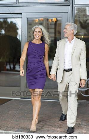 Stock Photo - Older Caucasian couple walking holding hands. Fotosearch
