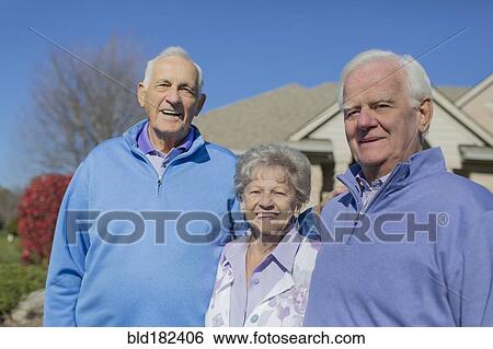 Stock Photograph - Older Caucasian friends smiling in yard. Fotosearch