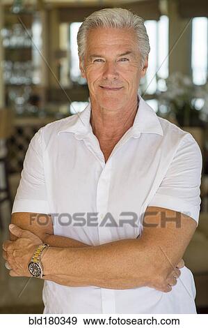 Older Caucasian man standing with arms crossed View Large Photo Image Stock Photo - Older Caucasian man standing with arms crossed. Fotosearch
