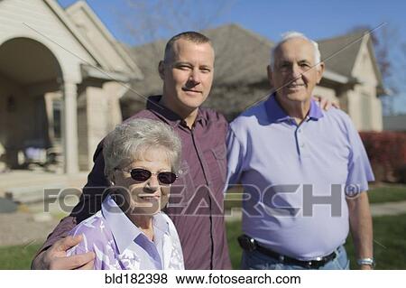 Older Caucasian parents and son smiling in yard View Large Photo Image Stock Photo - Older Caucasian parents and son smiling in yard. Fotosearch
