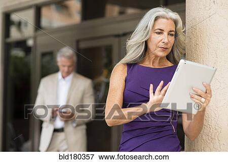 Older Caucasian people using technology outdoors View Large Photo Image Stock Photo - Older Caucasian people using technology outdoors. Fotosearch