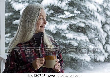 Older Caucasian woman drinking coffee on snowy patio View Large Photo Image Stock Photo - Older Caucasian woman drinking coffee on snowy patio. Fotosearch