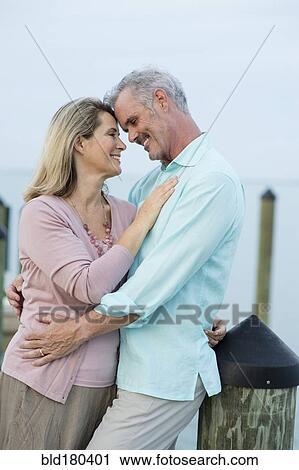 Stock Image - Older Caucasian woman hugging on pier. Fotosearch