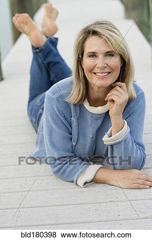 Older Caucasian woman laying on pier View Large Photo Image Stock Photo - Older Caucasian woman laying on pier. Fotosearch