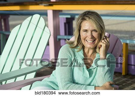 Picture - Older Caucasian woman sitting in lawn chair. Fotosearch