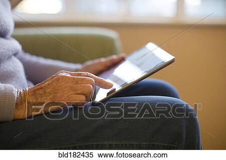 Stock Photography - Older Caucasian woman using digital tablet. Fotosearch