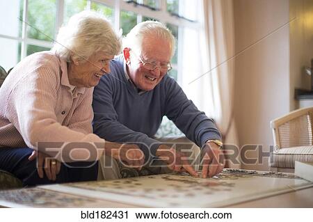 Older couple on sofa solving jigsaw puzzle View Large Photo Image Stock Image - Older couple on sofa solving jigsaw puzzle. Fotosearch