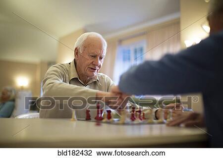 Stock Image - Older men playing chess. Fotosearch