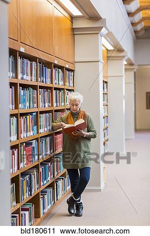 Older mixed race woman reading book in library View Large Photo Image Stock Image - Older mixed race woman reading book in library. Fotosearch