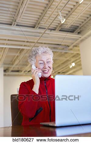 Stock Photo - Older mixed race woman working in art gallery. Fotosearch