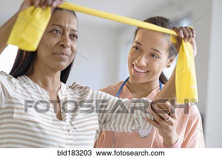 Patient having physical therapy in living room View Large Photo Image Stock Image - Patient having physical therapy in living room. Fotosearch