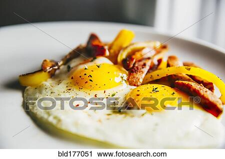 Stock Image - Plate of fried eggs and vegetables. Fotosearch