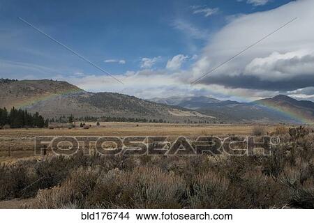 Picture - Rainbow over remote desert field. Fotosearch