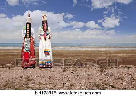 Stock Photograph - Rear view of women in traditional clothing in remote landscape. Fotosearch