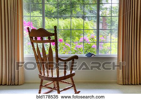 Rocking chair at living room window View Large Photo Image Stock Photography - Rocking chair at living room window. Fotosearch