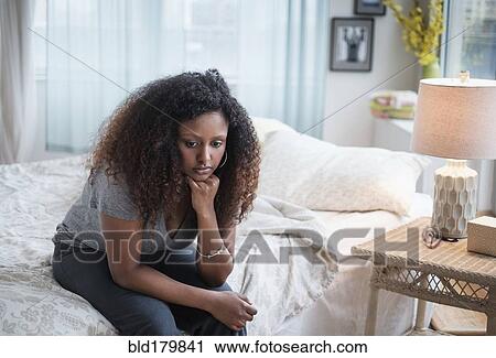 Sad Black woman sitting on bed View Large Photo Image Stock Image - Sad Black woman sitting on bed. Fotosearch