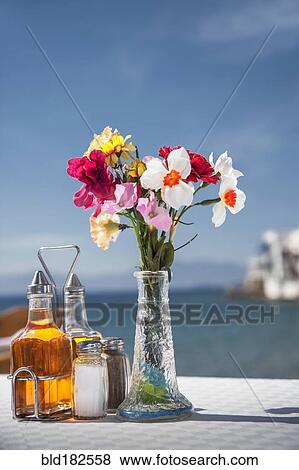 Seasonings and flowers on oceanfront cafe table View Large Photo Image Stock Photo - Seasonings and flowers on oceanfront cafe table. Fotosearch