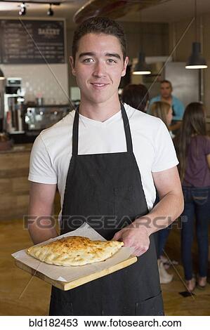 Stock Image - Server carrying calzone in cafe. Fotosearch