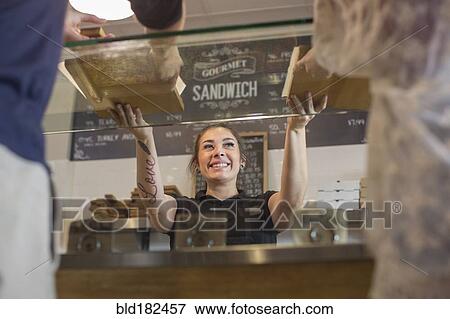 Stock Photo - Server handing pizza to customers in cafe. Fotosearch