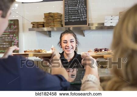 Server handing pizza to customers in cafe View Large Photo Image Stock Photo - Server handing pizza to customers in cafe. Fotosearch