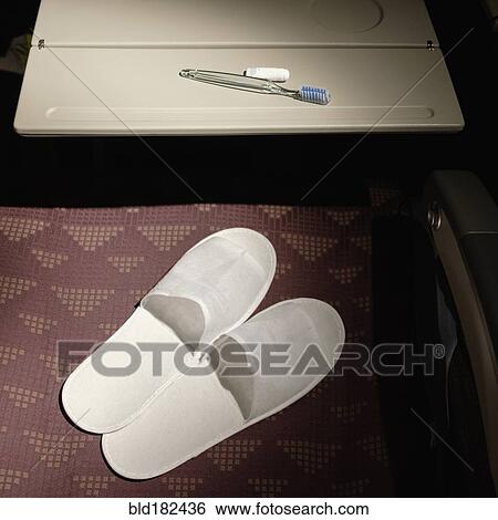 Slippers and toothbrush in airplane seat View Large Photo Image Stock Photograph - Slippers and toothbrush in airplane seat. Fotosearch