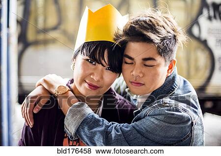 Stock Photo - Smiling Asian couple hugging. Fotosearch