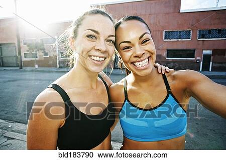 Stock Image - Smiling athletes hugging outdoors. Fotosearch