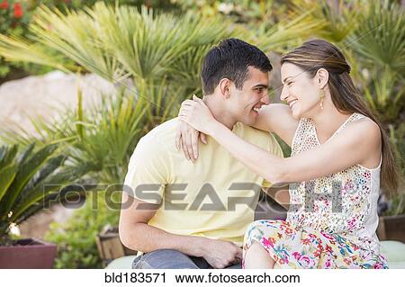 Stock Image - Smiling couple hugging outdoors. Fotosearch